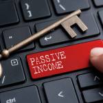Closed up finger on keyboard with word PASSIVE INCOME