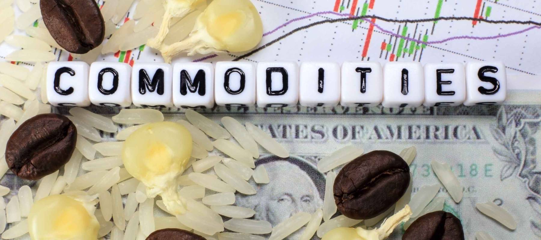 Coffee bean, rice, corn and letter cube on dollar and candle stick chart background. Conceptual image of commodity trading.