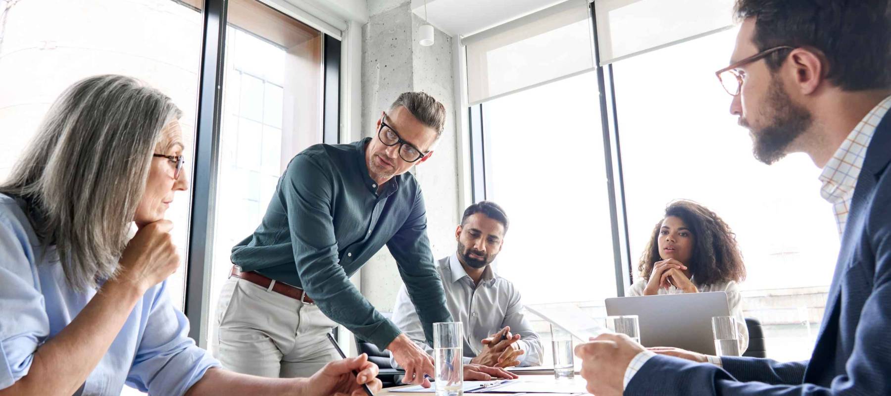 Male mature caucasian ceo businessman leader with diverse coworkers
