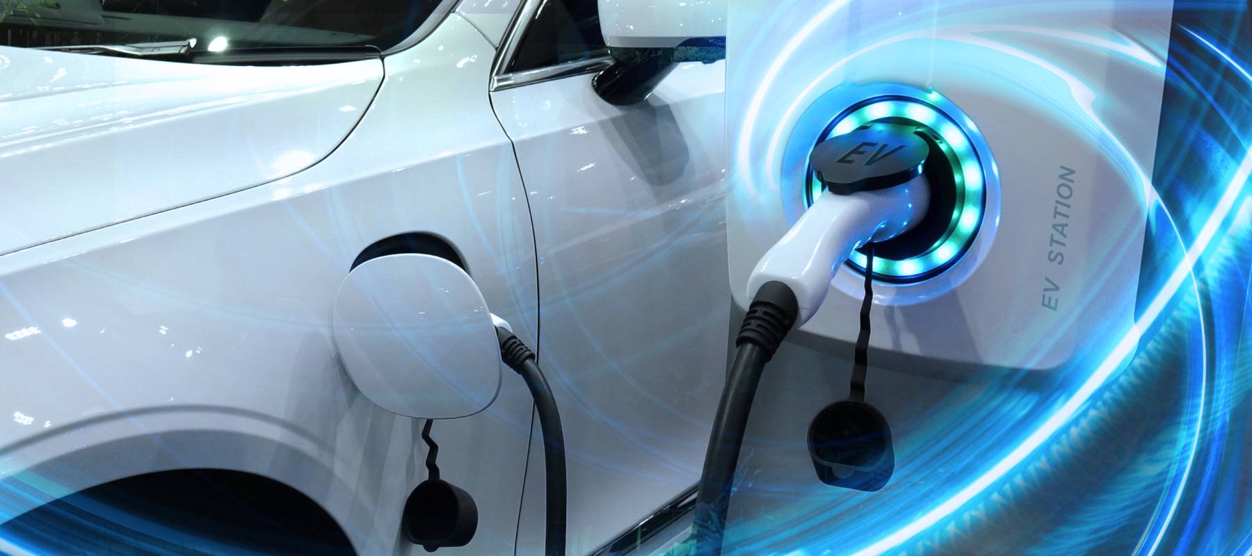 EV Car or Electric vehicle at charging station with the power cable supply plugged in.