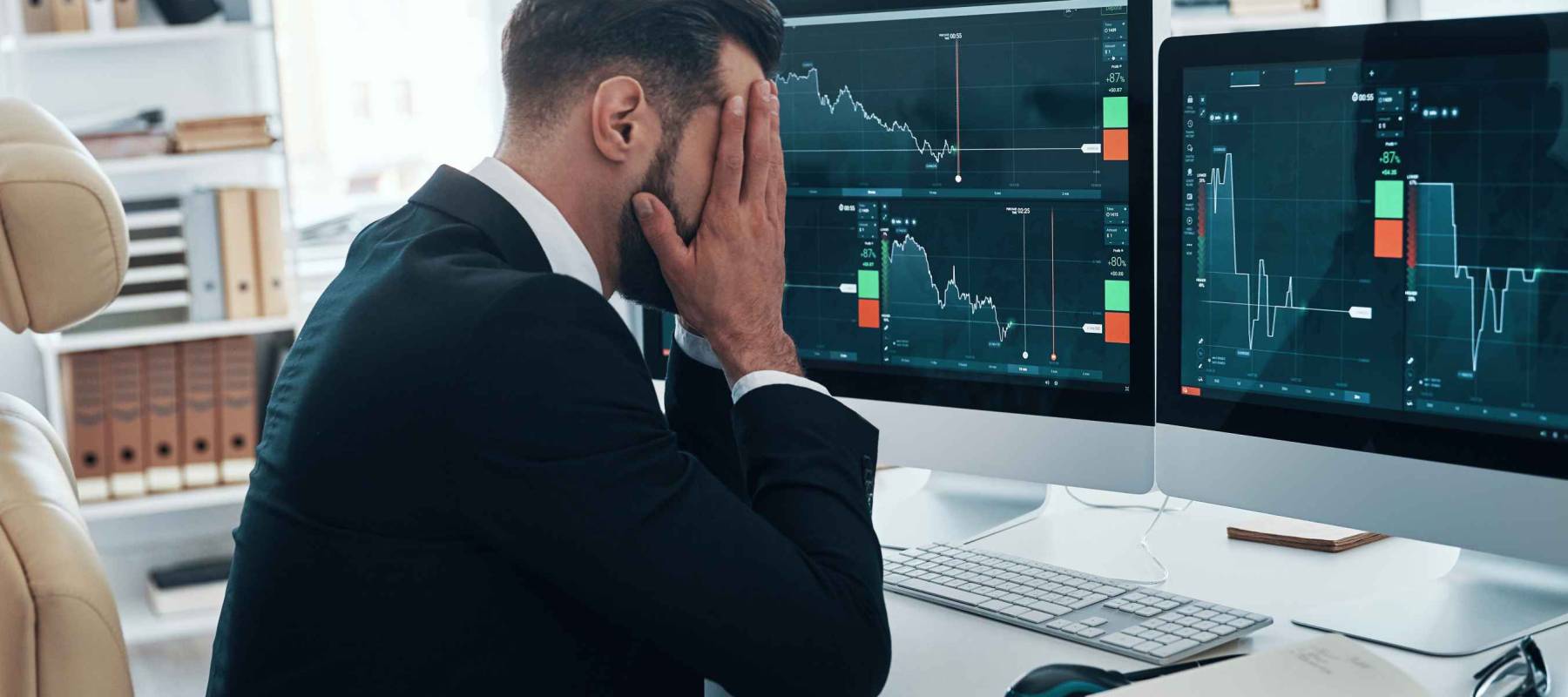 Frustrated young man in formalwear keeping head in hands while working in the office