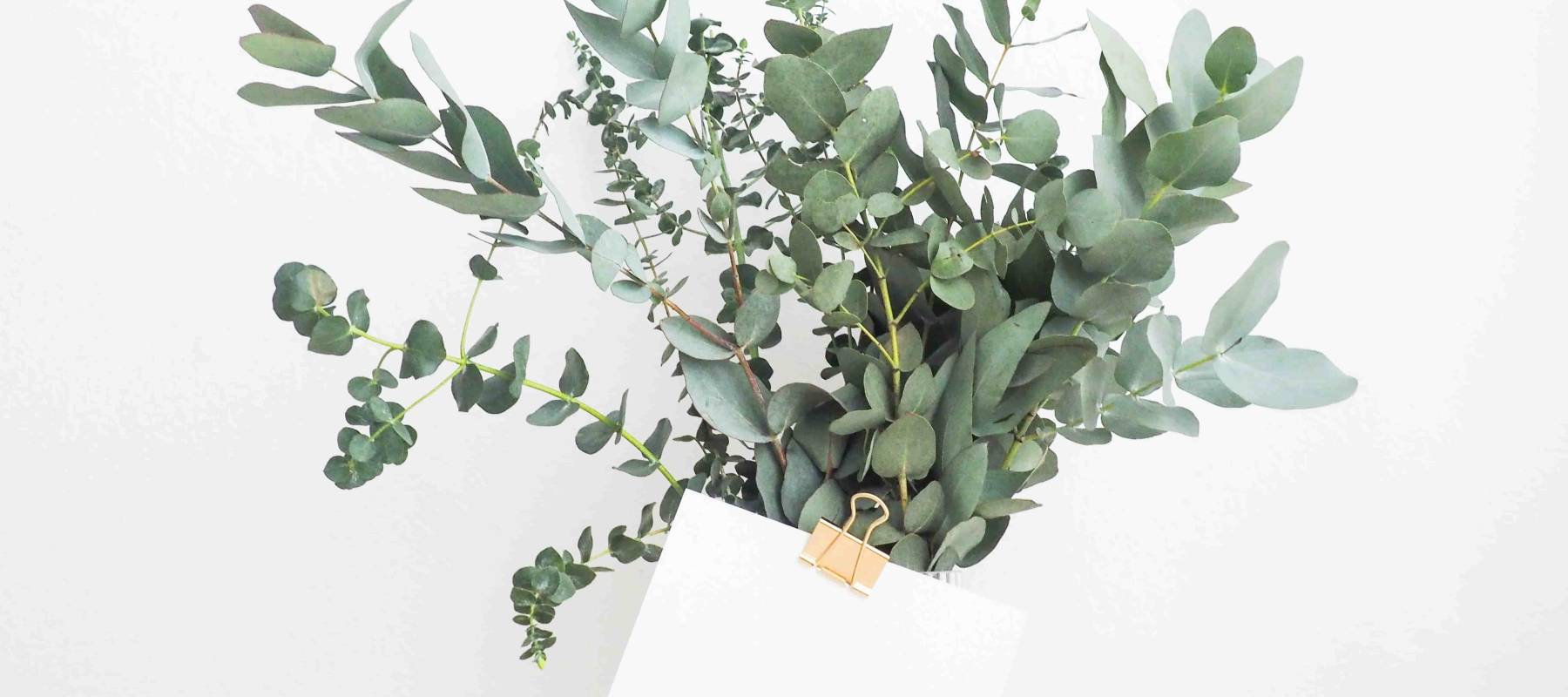 bouquet of flowers in vase with envelope clipped to it