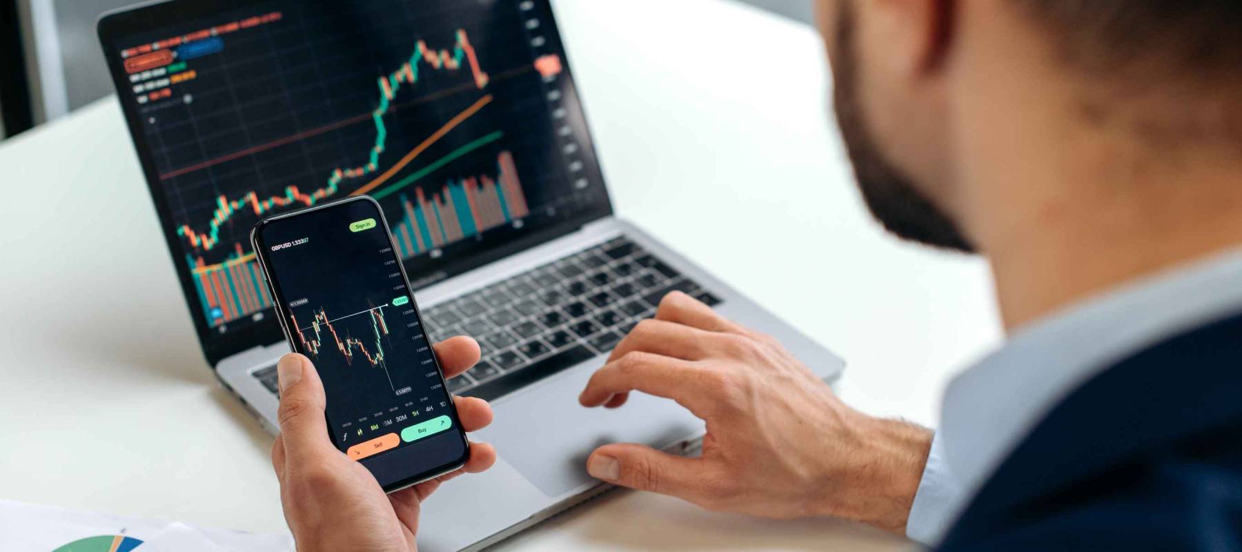 Close-up of male hands holding smartphone. Trader investor analyst using mobile phone app for cryptocurrency stock market, analyzing graph showing growth