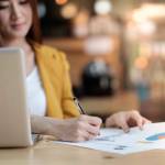 Asian business woman working with document and laptop in office.