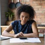 Serious mixed race female calculate utility charges check payments sum by loan contract to avoid scam.
