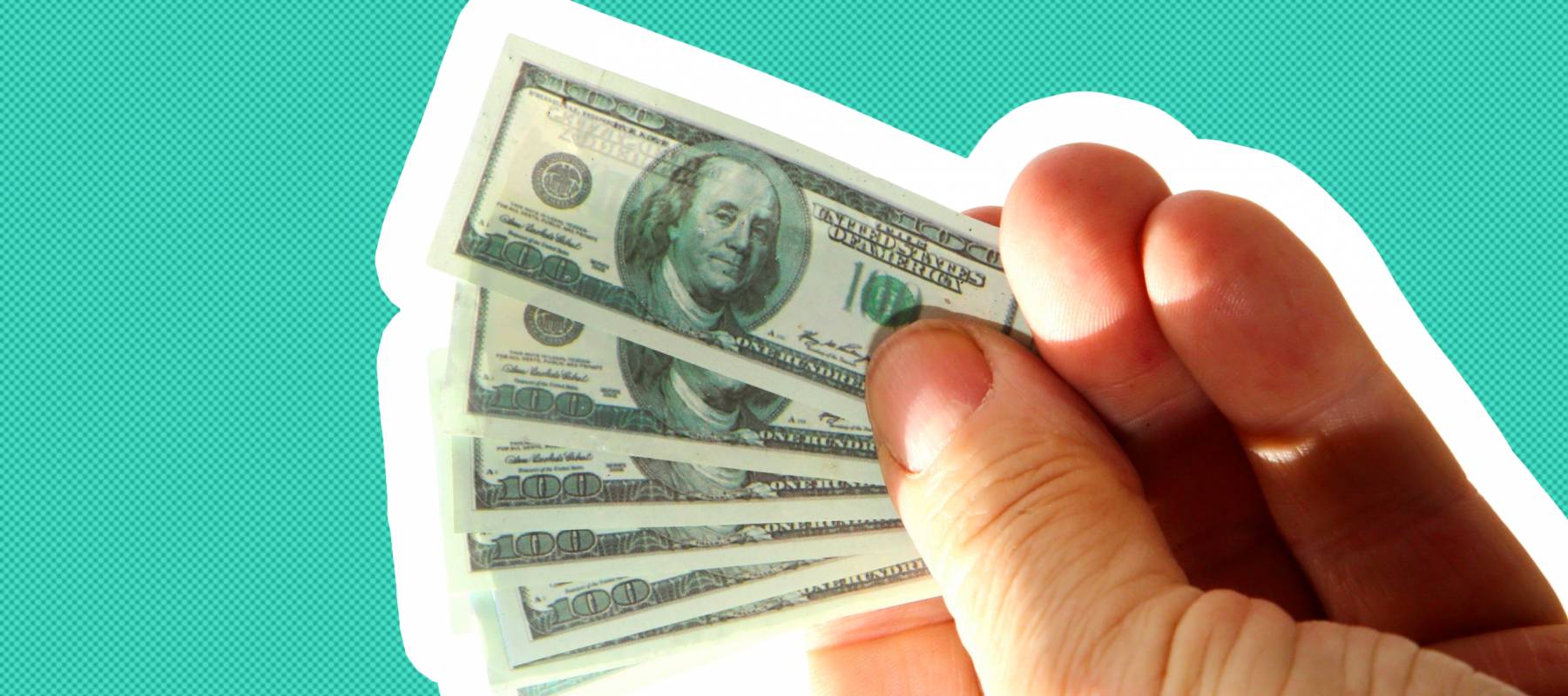 miniature money. small $100.00 dollar bills in a normal mans hands.