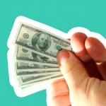 miniature money. small $100.00 dollar bills in a normal mans hands.