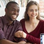 Smiling multiracial couple customers shaking hands with mortgage broker