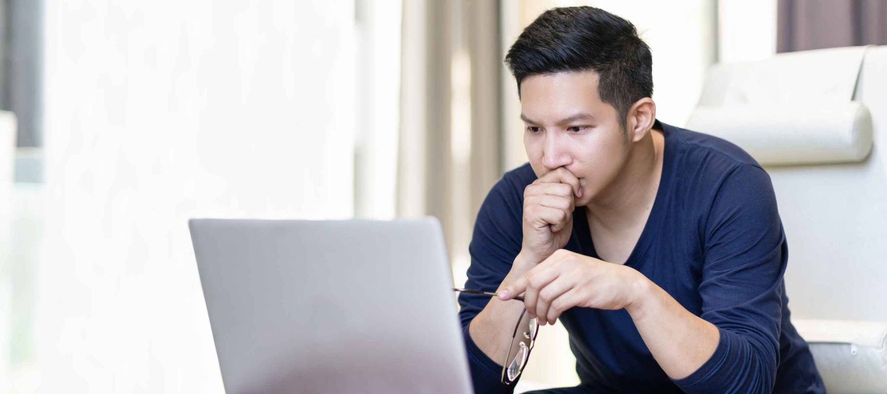 Seriously confident asian young freelancer in smart casual working