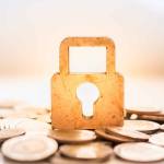 Money and Security Concept. Wooden master key lock icon on pile of coins.