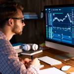 trader analyst looking at computer monitor, analyzing cryptocurrency indexes stock market