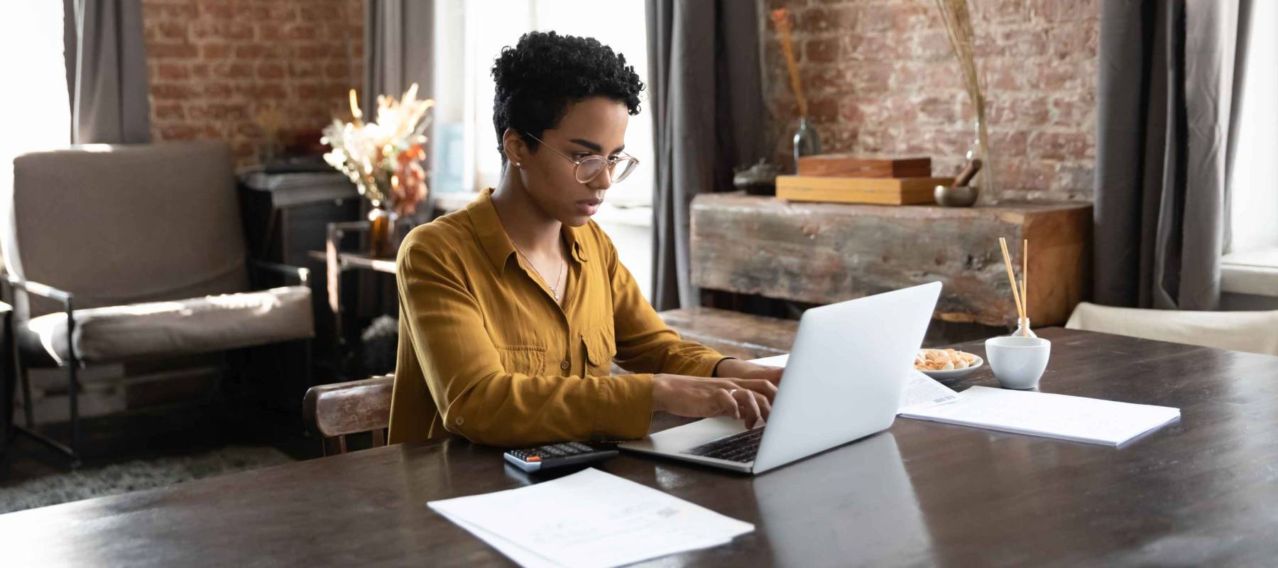 Focused millennial African owner woman using payment banking financial docs