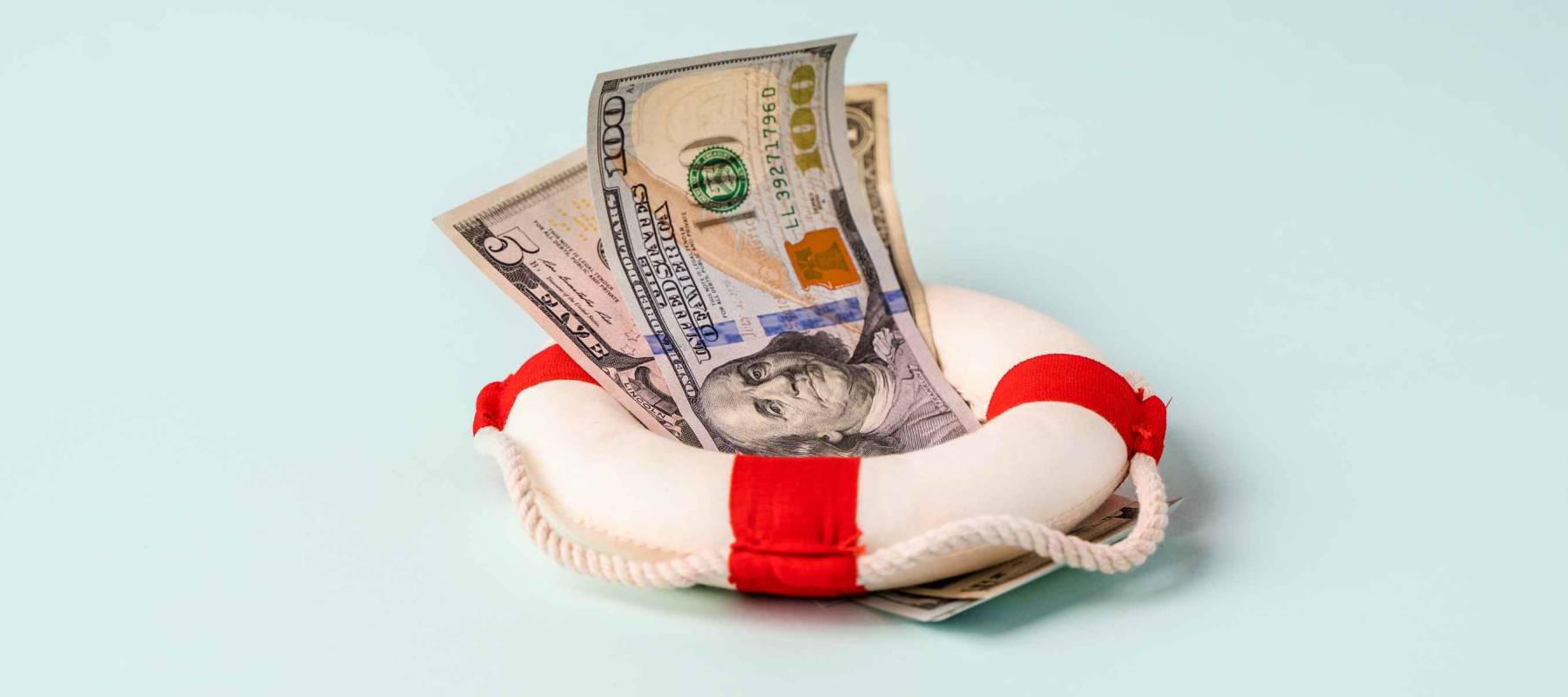 A lifebuoy with banknotes lie on a blue background, the concept of assistance and security in finance