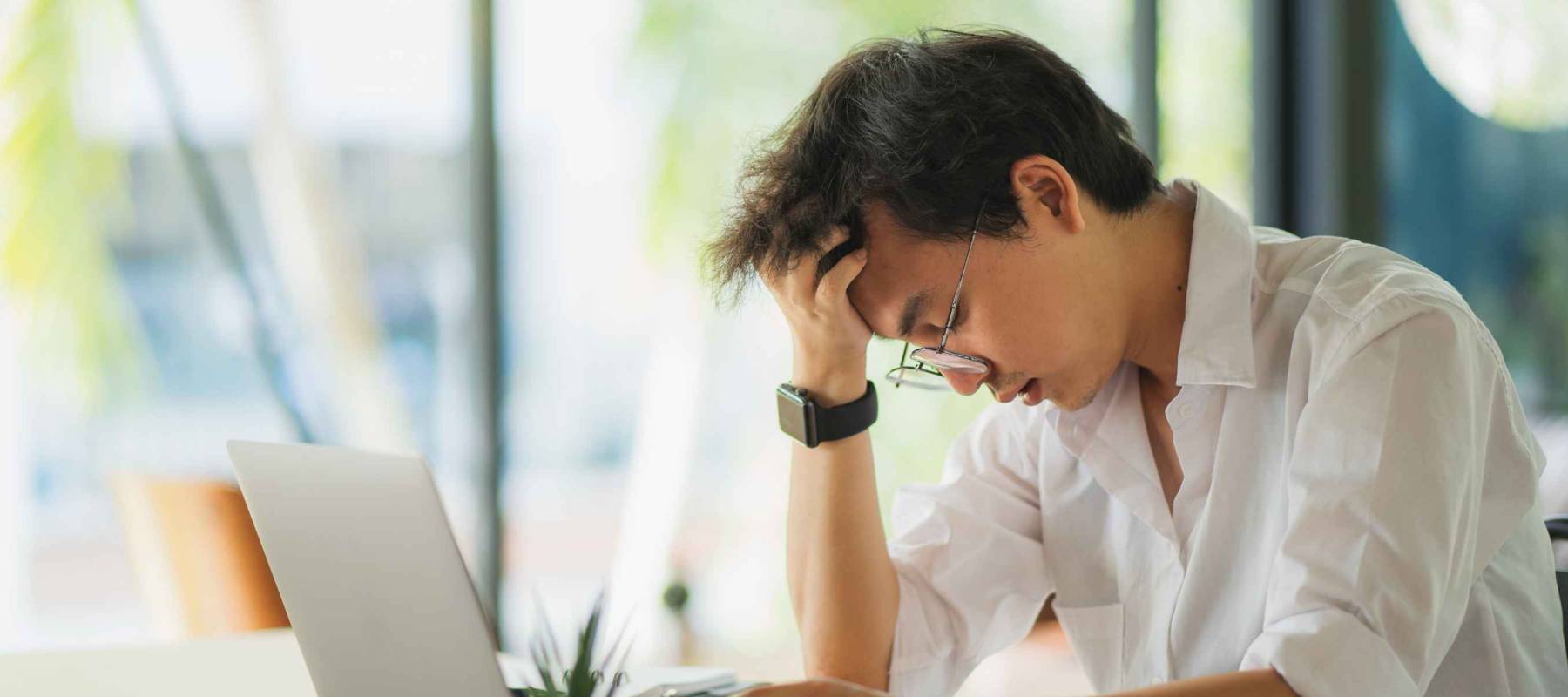 Shot of stressed asian business man in the office.