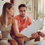 Unhappy, stressed and upset couple paying bills or debt online on with a laptop at home getting angry, planning budget.
