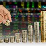Hand make coin graph in stock index background. Financial education concept with hand putting many coins.  Tower of the coin is mean money or investment or saving, growth going up