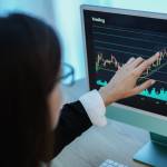 Trader business woman studying stock market at home - Focus on hand