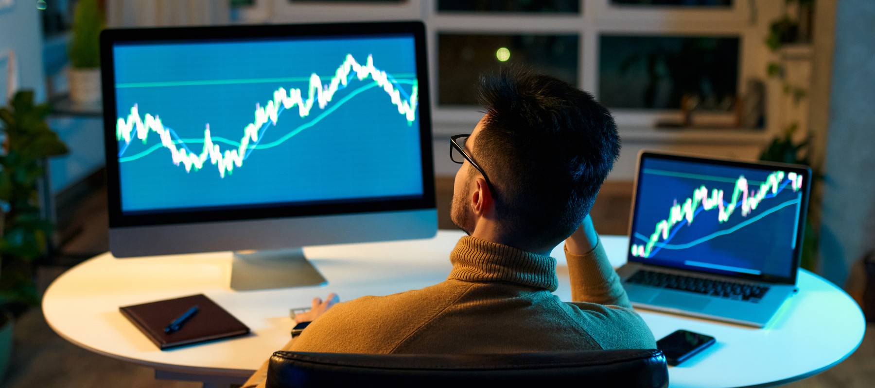 Crypto trader investor analyst looking at computer screen analyzing financial chart data on pc and laptop monitor
