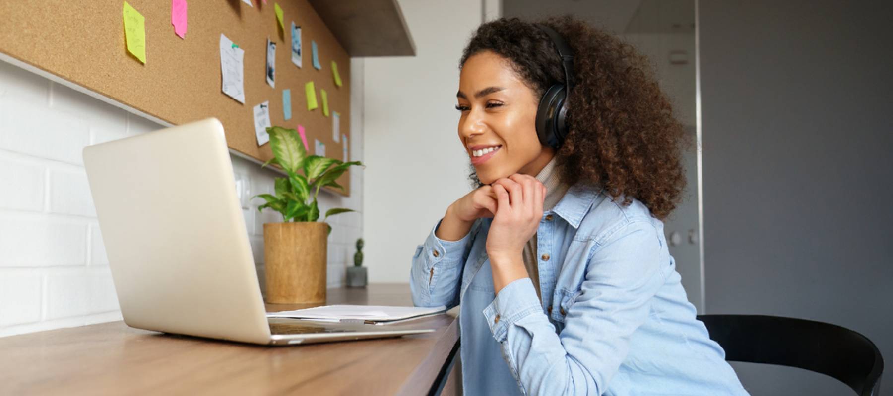 a young woman looking at her open laptop in home office