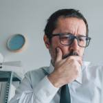 Worried shareholder analyzing stock prices on online market from business office, selective focus