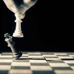 Bitbuy vs. coinbase  - two king chess pieces shown on chess board with one knocking over the other
