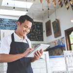 portrait of asian young male cafe owner with tablet