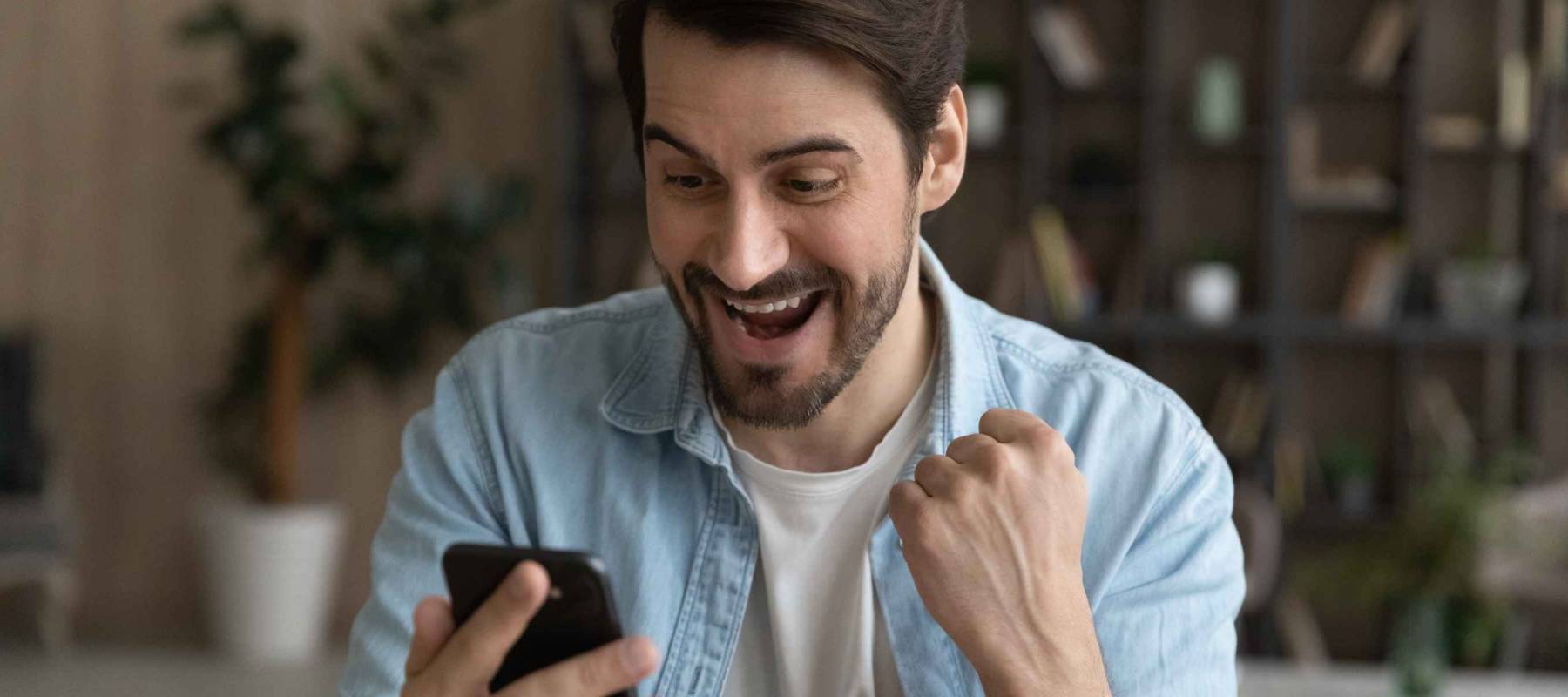 bearded male looking at cell phone after buying solana smiling