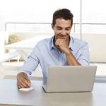 Dude working from home with laptop, smiling