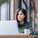 Portrait of Young Smart Asian Woman Freelance Online Working from Home with Laptop at Home Living Room