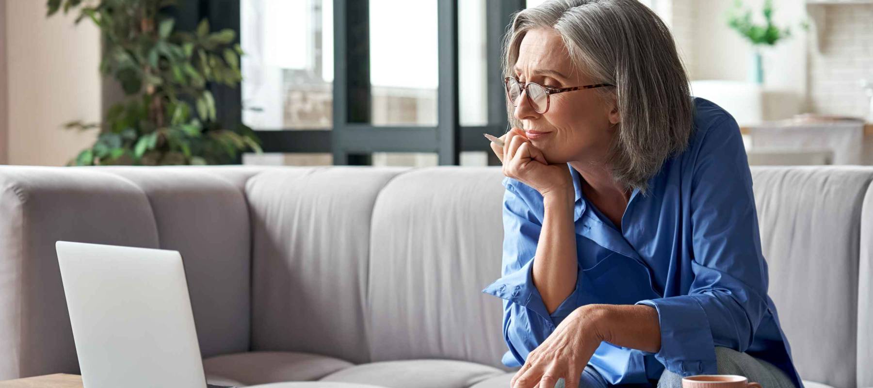 Senior mature older woman watching business training, online webinar on laptop computer
