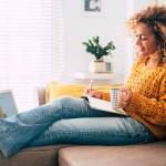Beautiful single woman work at home with paper book and computer laptop together in old and modern job style concept