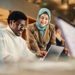 Two Coworkers Talking and Congratulating Eachother with a High Five. Muslim Female Chief Strategist Motivating Black Male Colleague,
