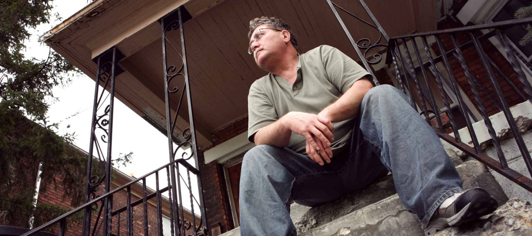 Man sitting on the steps of a house