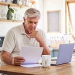 Planning, documents and finance with elderly man on laptop i