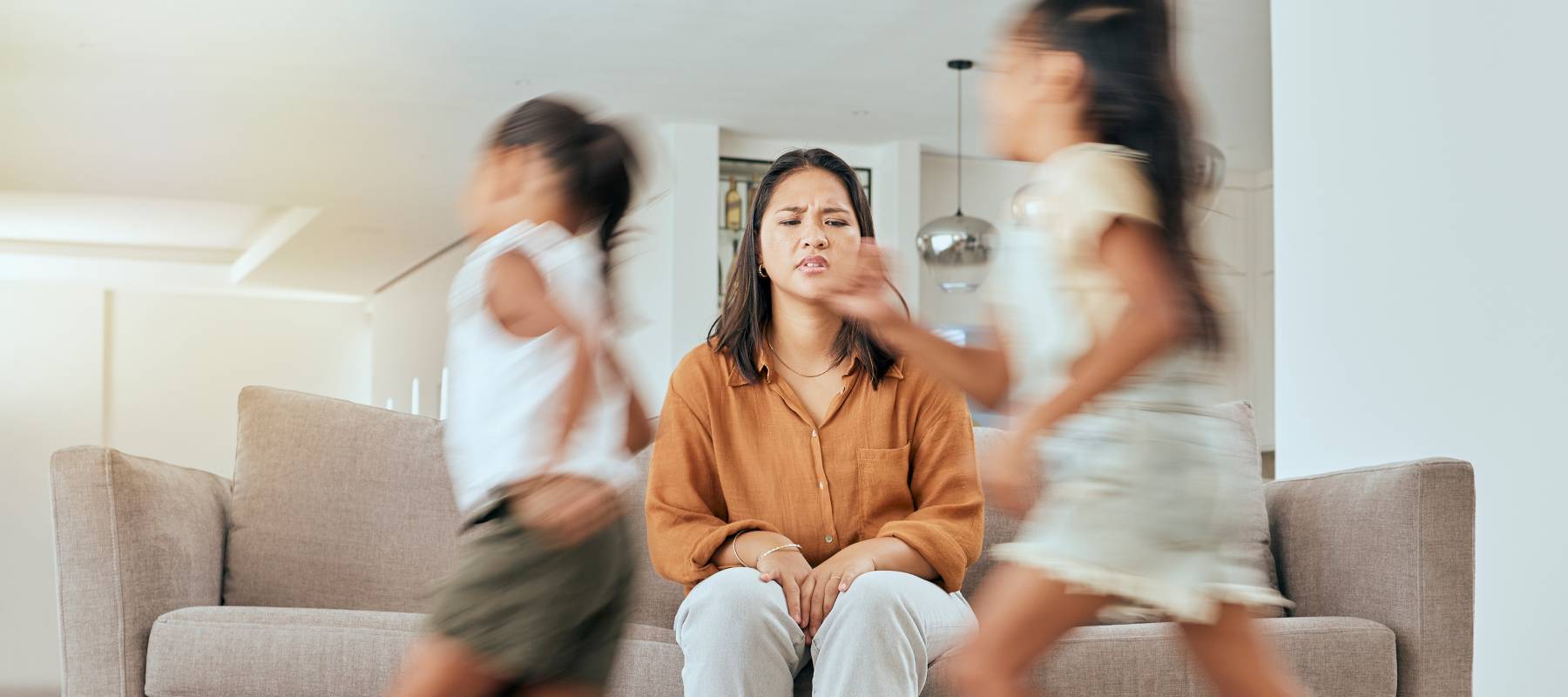 Mother and children running with energy with mom feeling anxiety.
