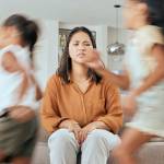 Mother and children running with energy with mom feeling anxiety.