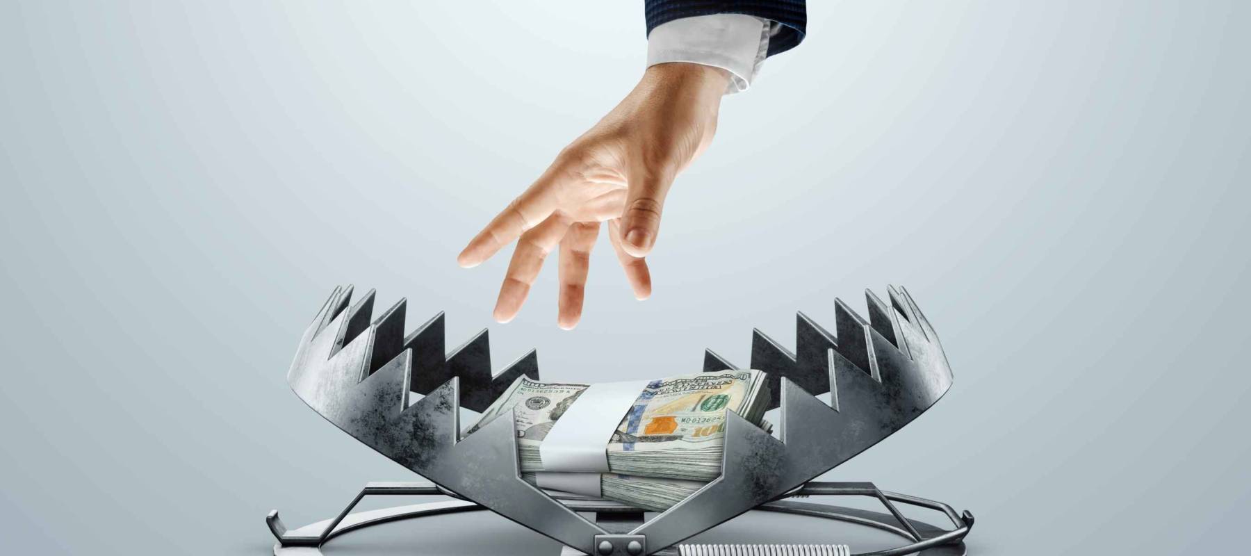 A man's hand takes dollars from a bear trap. The concept of mortgage, dirty money, bribe, corruption, easy money, debt, credit. mixed media