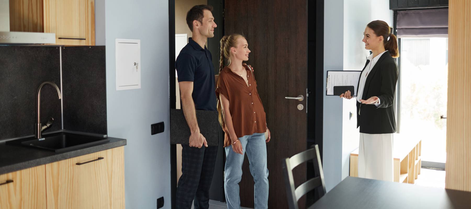 Side view portrait of female real estate agent meeting young couple