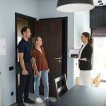 Side view portrait of female real estate agent meeting young couple