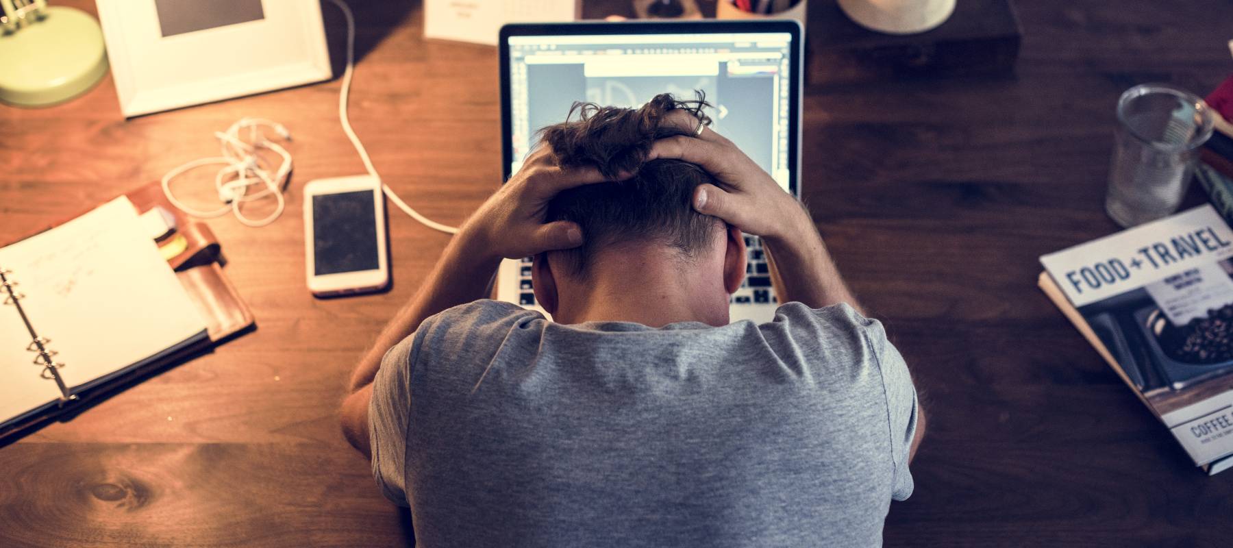 Man stressed while working on laptop.