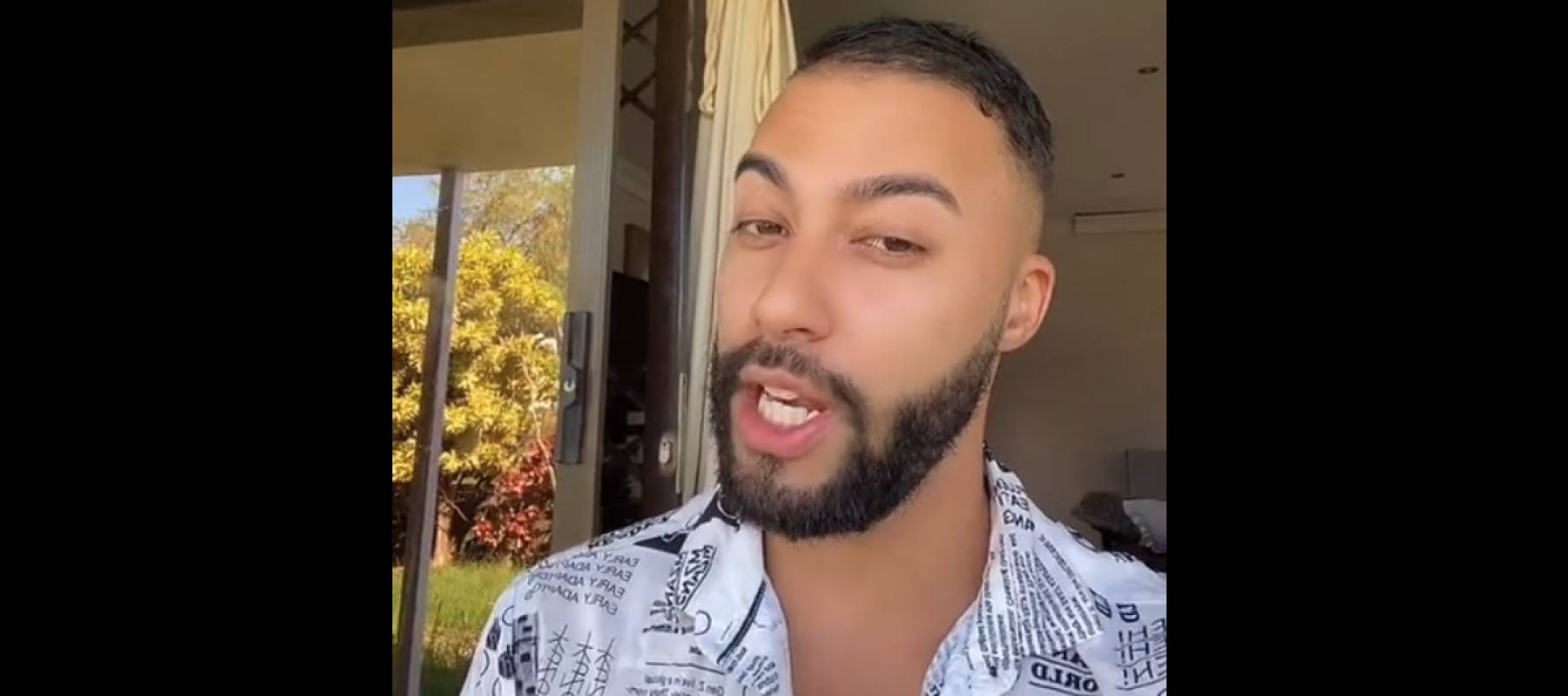 Man looks directly at the camera with a sly expression.