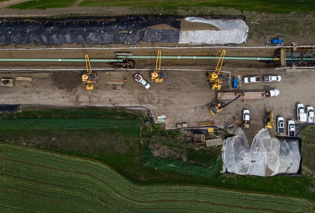 In this photograph taken with a drone, workers lay pipe during construction of the Trans Mountain pipeline expansion on farmland, in Abbotsford, B.C., on Wednesday, May 3, 2023. A B.C. First 