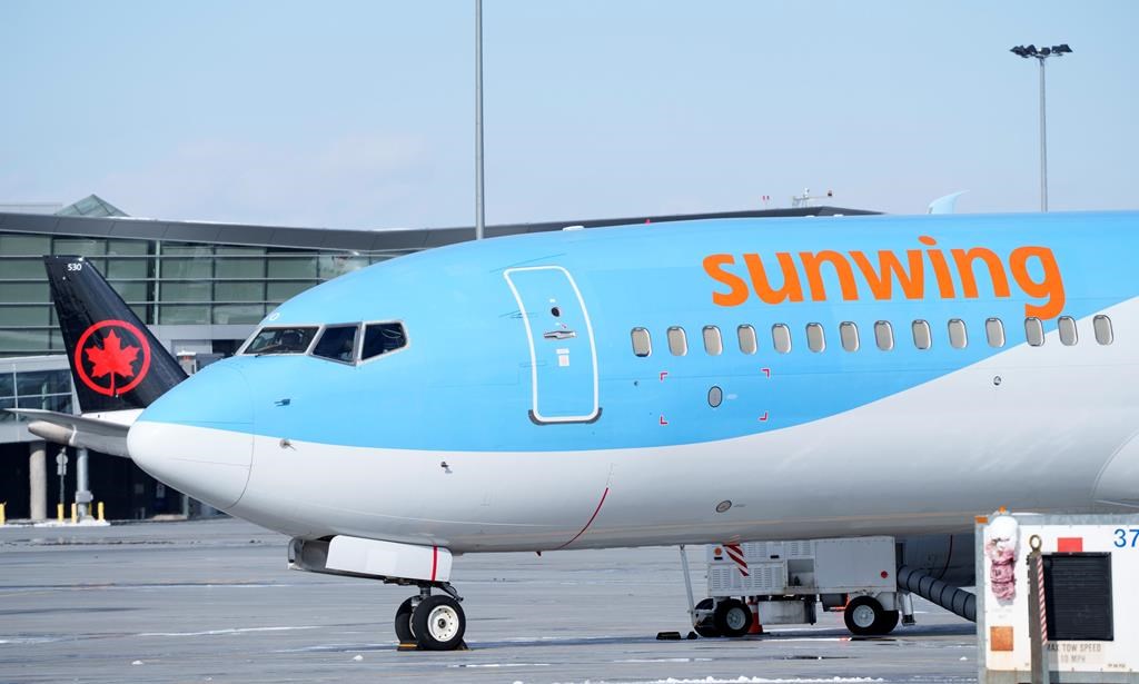A Sunwing aircraft is parked at Montreal Trudeau airport in Montreal on Wednesday, March 2, 2022.WestJet says it aims to wind down Sunwing Airlines and integrate the low-cost carrier into its