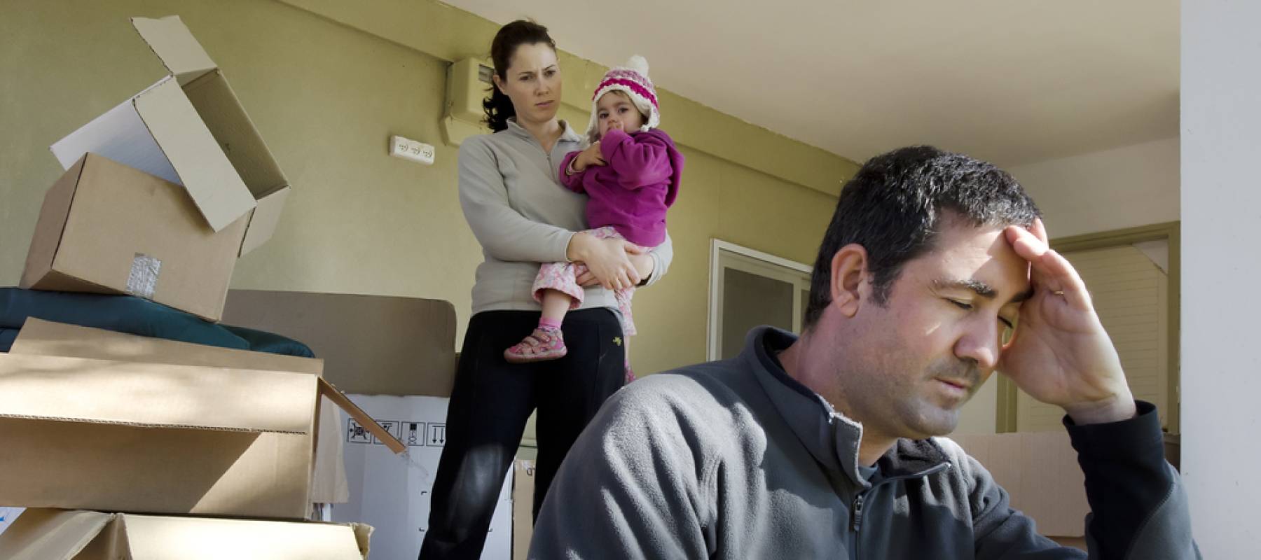 Upset young parents and their daughter outside their home.