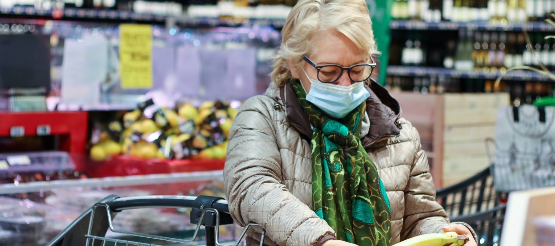 An older woman shopping at a grocery store.