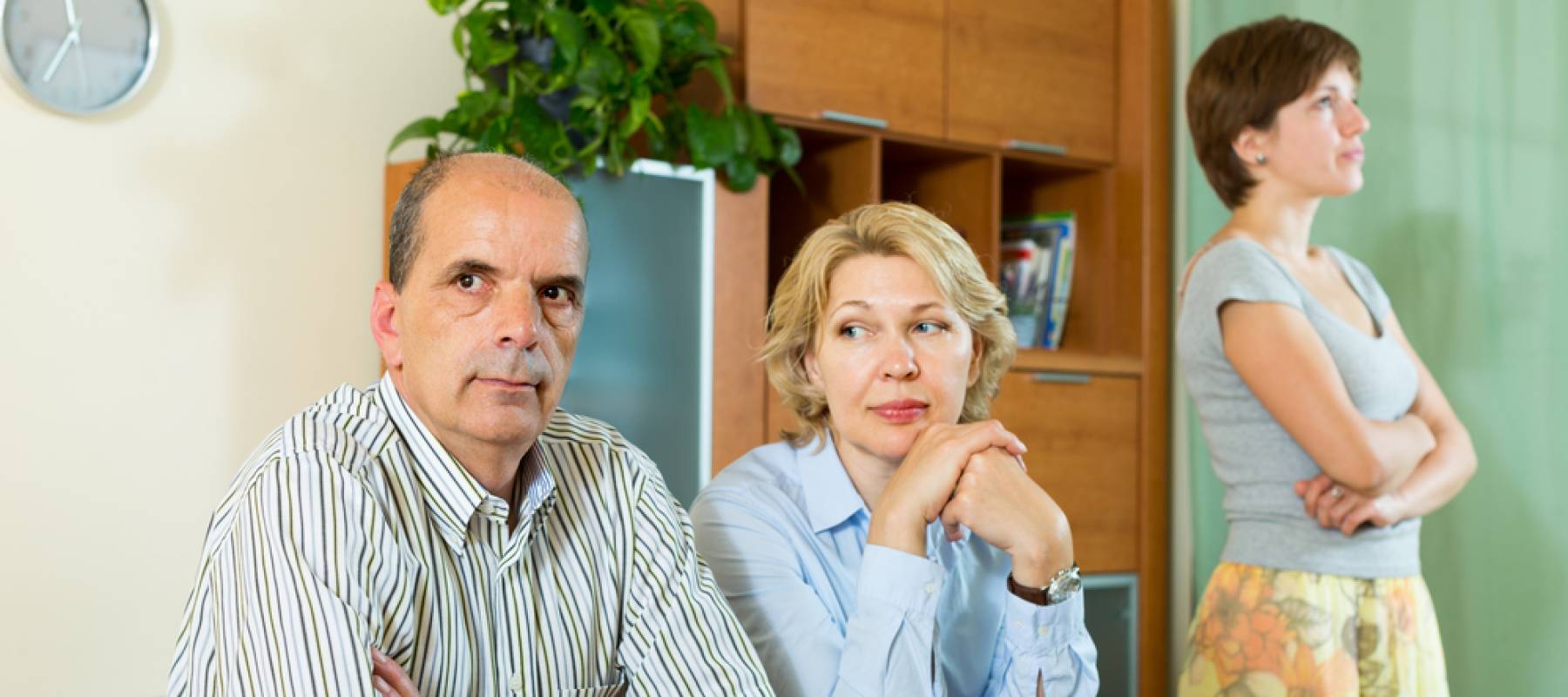Adult daughter and mature parents having serious talking at home.