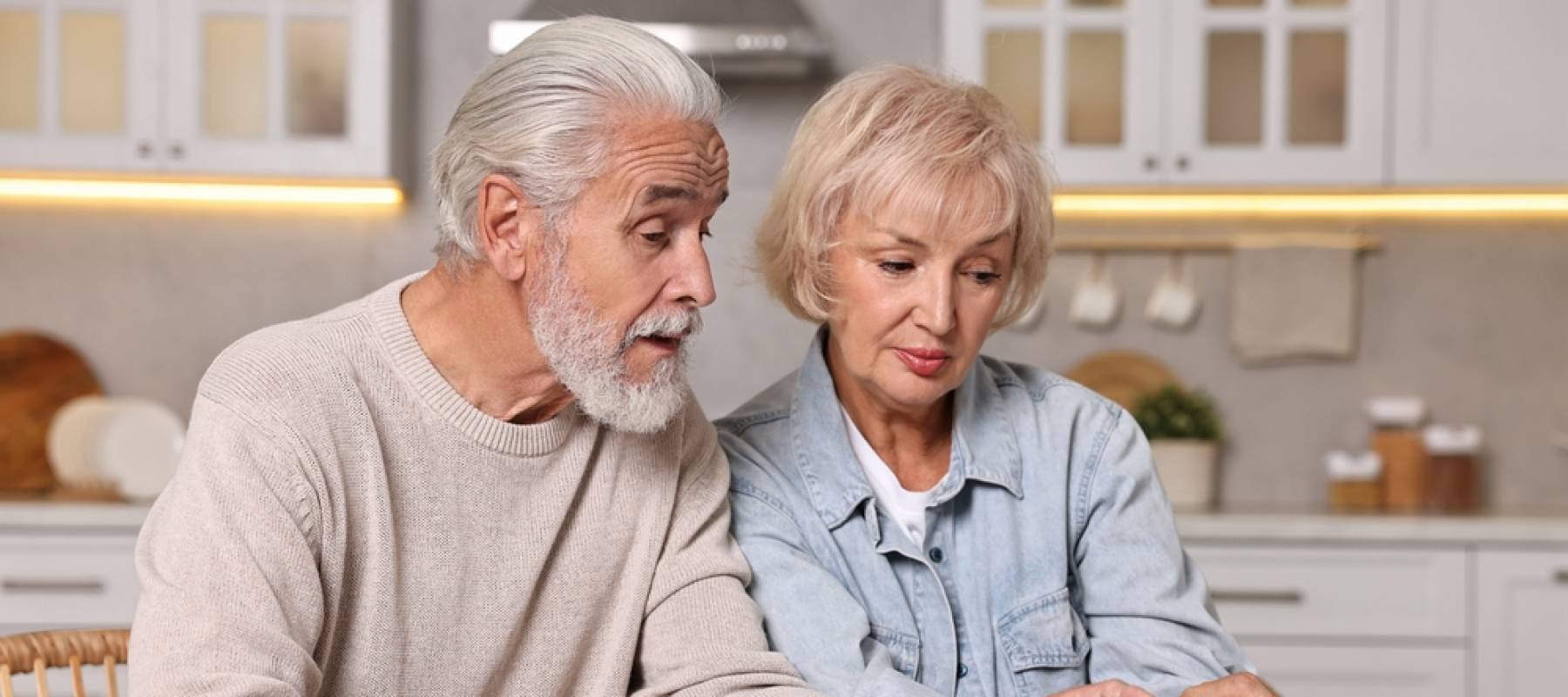 Pension savings. Senior couple planning budget at wooden table indoors