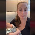 Young mother holding a baby, looking directly into camera and speaking.