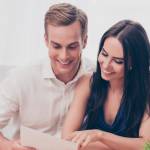 couple looking at paper and smiling