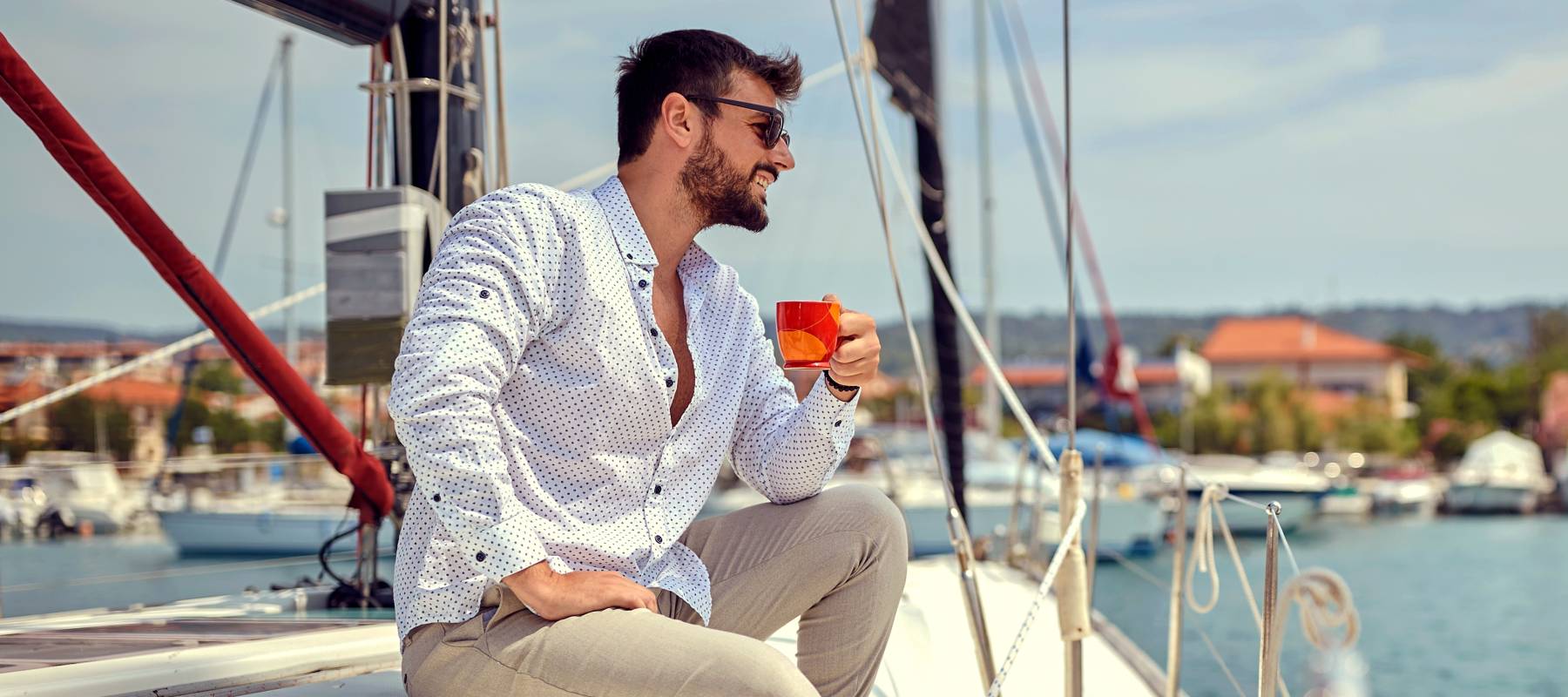 Rich, handsome man sailing alone on the yacht.